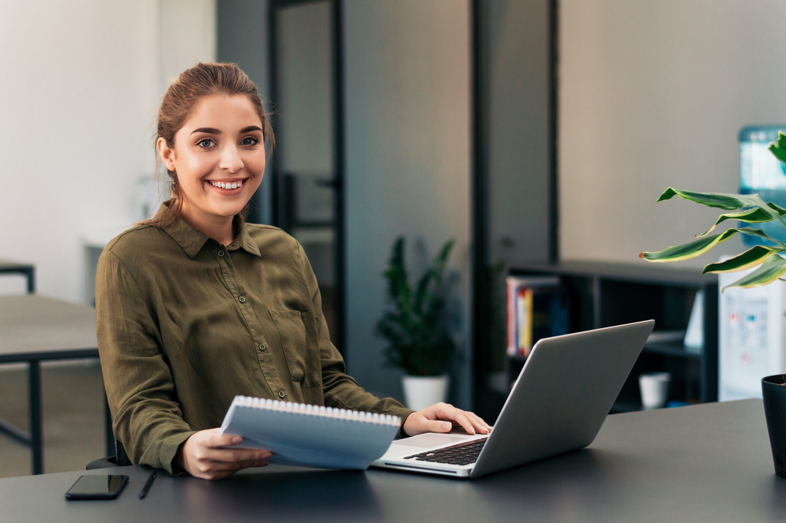 Portrait of young freelancer woman sitting at her desk.